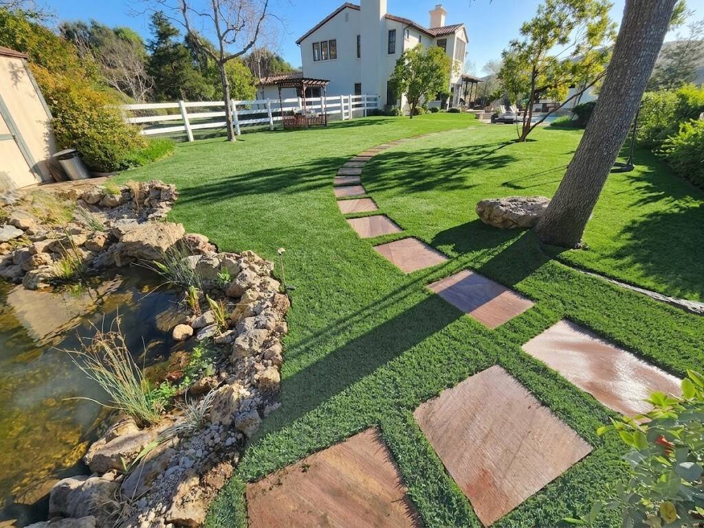 Flagstone stepping-paver path and natural stone-edged pond hardscape in a Thousand Oaks backyard